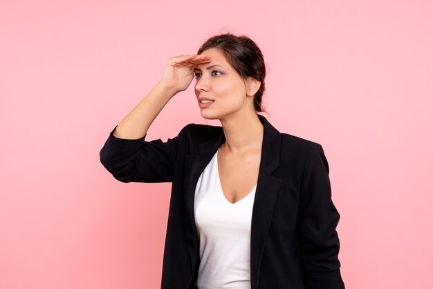 Vista frontal mujer joven en chaqueta oscura sobre fondo rosa