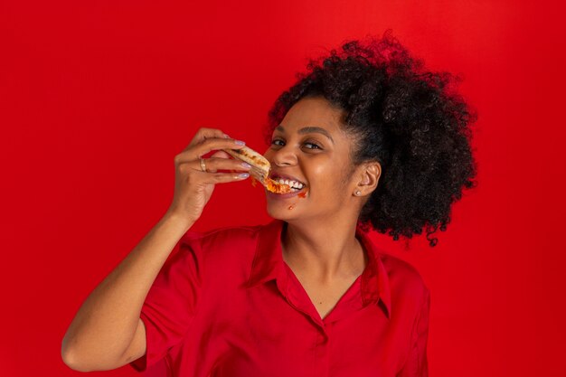 Vista frontal mujer joven comiendo deliciosa pizza