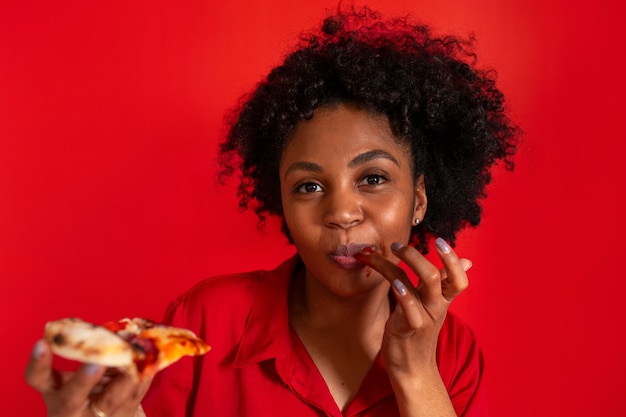 Vista frontal mujer joven comiendo deliciosa pizza