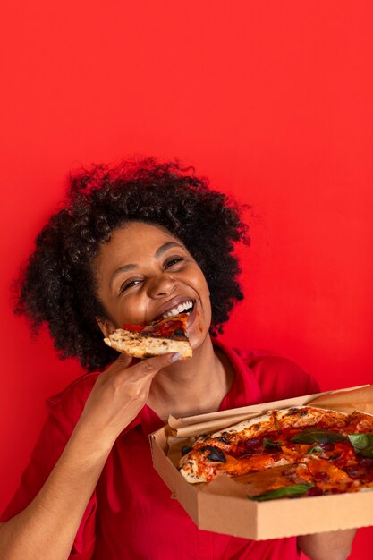 Vista frontal mujer joven comiendo deliciosa pizza