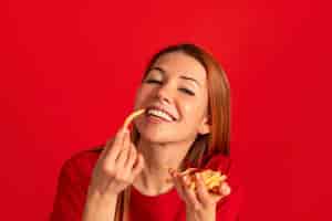 Foto gratuita vista frontal mujer joven comiendo papas fritas