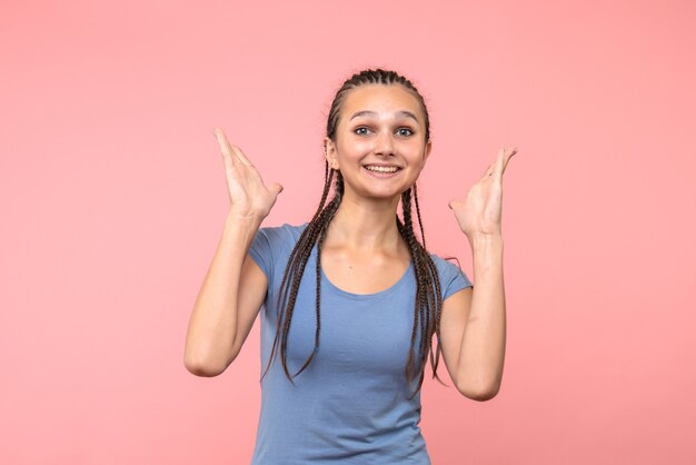 Vista frontal de la mujer joven emocionada en rosa