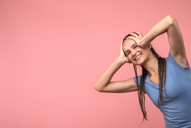 Vista frontal de la mujer joven emocionada en rosa