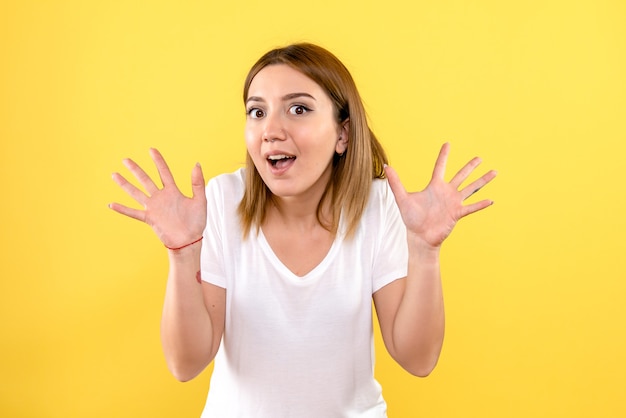 Vista frontal, de, mujer joven, emocionado, en, pared amarilla