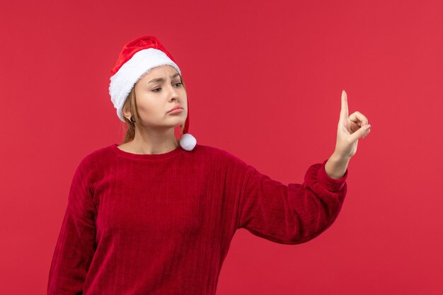 Vista frontal mujer joven con expresión disgustada, vacaciones rojo navidad