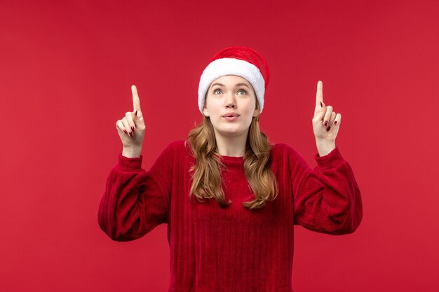 Vista frontal mujer joven con expresión emocionada, rojo de vacaciones de Navidad