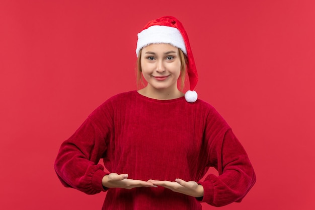 Vista frontal mujer joven con expresión sonriente, rojo de vacaciones de Navidad