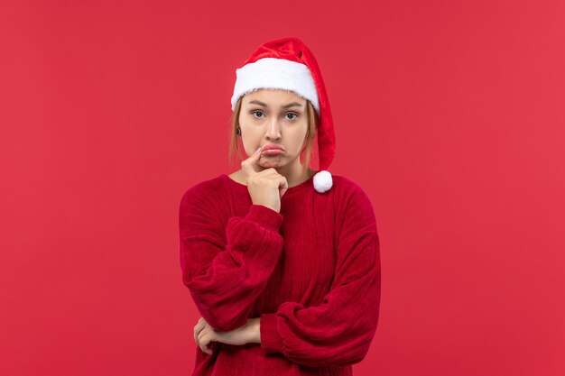 Vista frontal mujer joven con expresión triste, rojo vacaciones navidad