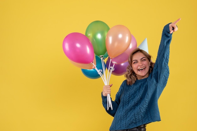 Foto gratuita vista frontal mujer joven con globos de colores