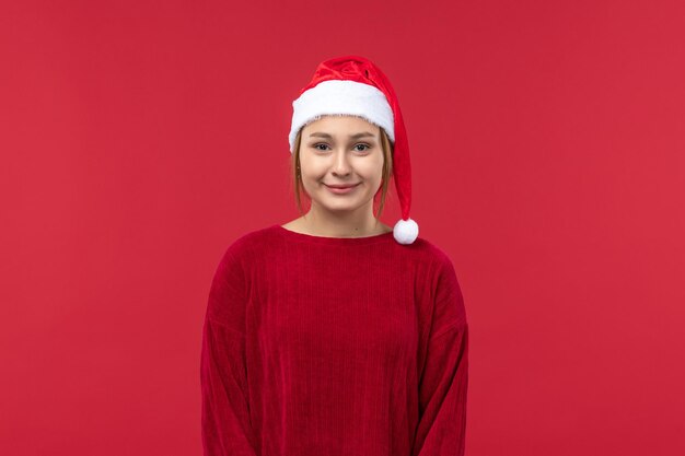 Vista frontal mujer joven en gorra roja y humor navideño, nochebuena roja