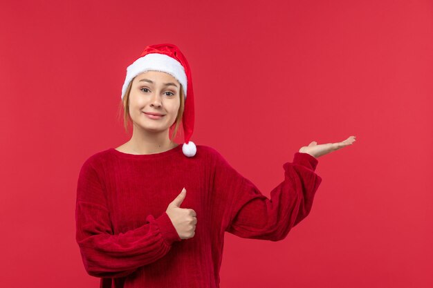 Vista frontal mujer joven en gorra roja y humor navideño, nochebuena roja