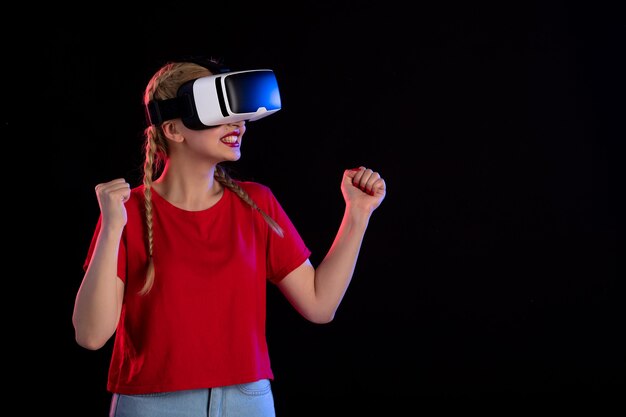 Vista frontal de la mujer joven jugando vr en fantasía de ultrasonido juego oscuro