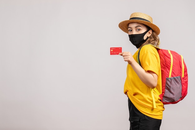 Vista frontal, mujer joven, llevando, máscara negra, tenencia, tarjeta