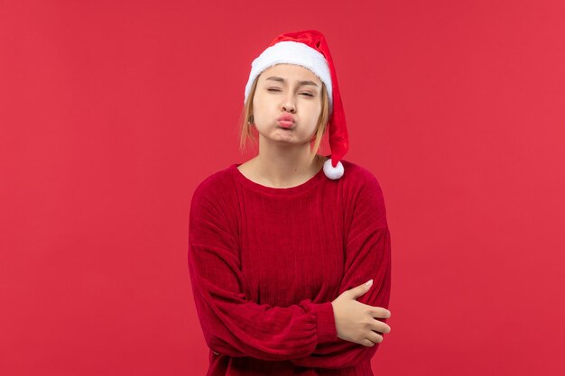 Vista frontal mujer joven mostrando sus labios, vacaciones de navidad rojo