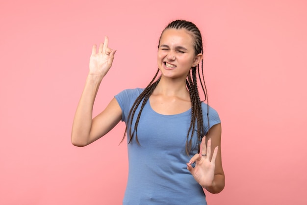 Vista frontal de la mujer joven con los ojos cerrados en rosa