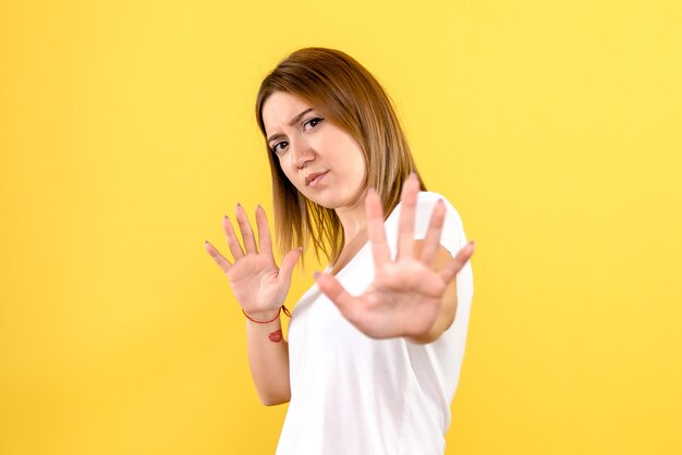 Vista frontal, de, mujer joven, en, pared amarilla