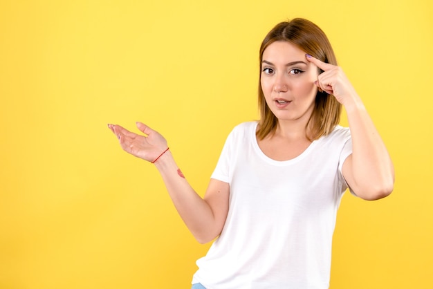 Vista frontal, de, mujer joven, en, pared amarilla