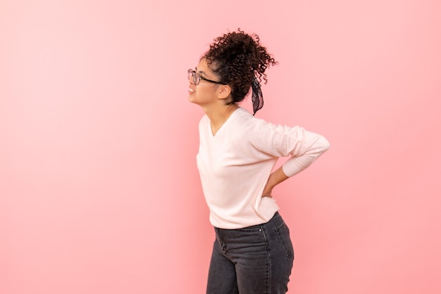 Foto gratuita vista frontal de la mujer joven en la pared rosa