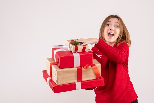 Vista frontal mujer joven de pie con regalos en sus manos