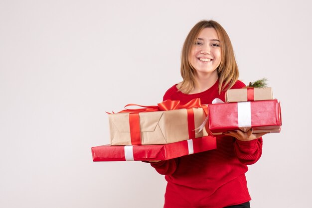 Vista frontal mujer joven de pie con regalos en sus manos