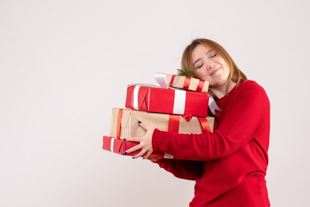 Vista frontal mujer joven de pie con regalos en sus manos