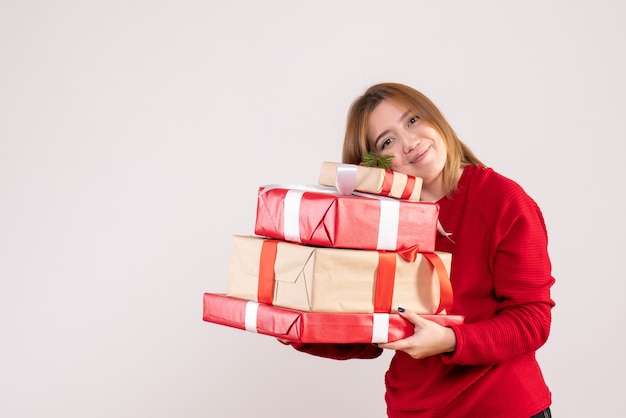 Vista frontal mujer joven de pie con regalos en sus manos