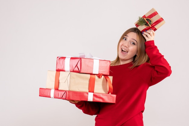 Vista frontal mujer joven de pie con regalos en sus manos