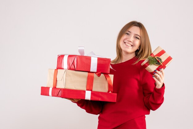 Vista frontal mujer joven de pie con regalos en sus manos