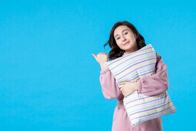 Vista frontal mujer joven en pijama rosa con almohada en azul noche fiesta de color reposo en cama sueño insomnio sueño
