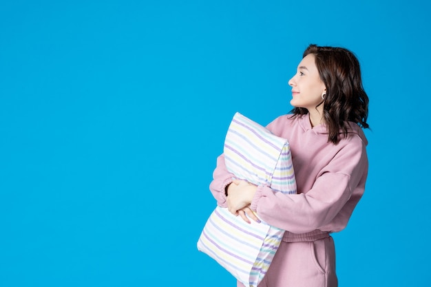 Foto gratuita vista frontal mujer joven en pijama rosa con almohada en azul