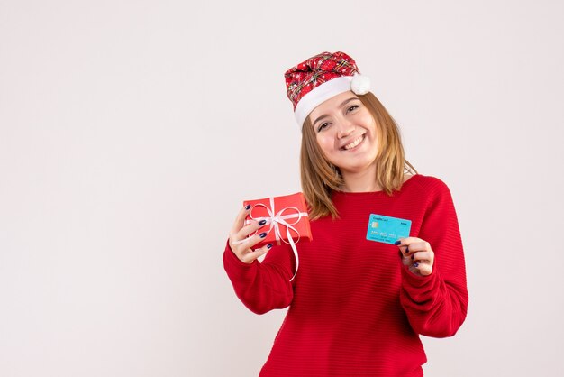 Vista frontal mujer joven con poco presente de Navidad y tarjeta bancaria