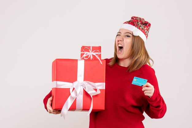 Vista frontal mujer joven con poco presente de Navidad y tarjeta bancaria