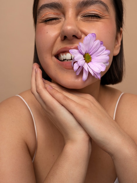 Foto gratuita vista frontal mujer joven posando con flor