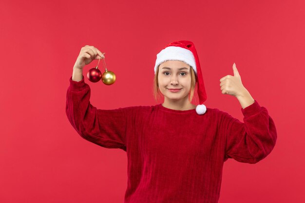 Vista frontal mujer joven posando con juguetes navideños, emociones navideñas navideñas