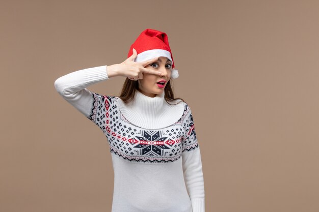 Vista frontal mujer joven posando sobre fondo marrón emoción navidad año nuevo