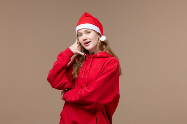 Vista frontal mujer joven posando sobre fondo marrón Navidad emoción vacaciones