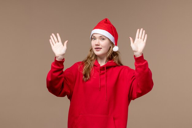 Vista frontal mujer joven posando sobre fondo marrón vacaciones de emociones de navidad