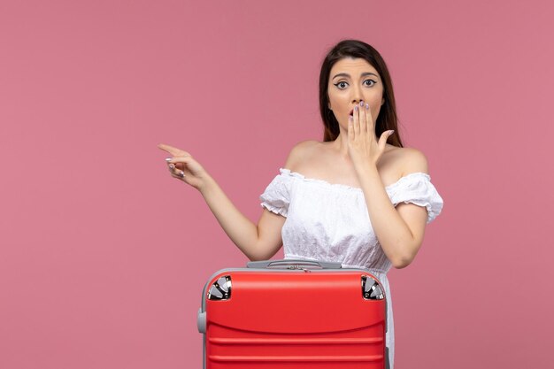 Vista frontal mujer joven preparándose para las vacaciones con expresión de sorpresa sobre fondo rosa viaje al extranjero viaje viaje por mar