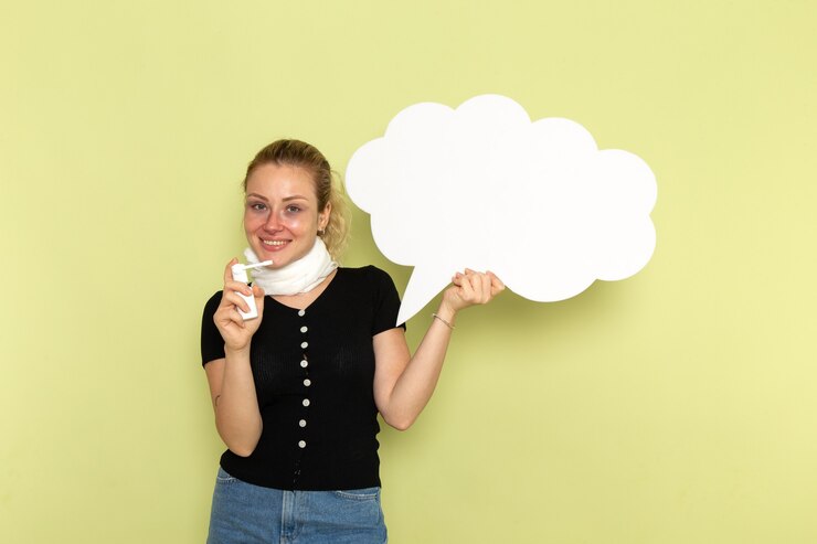 Foto gratuito vista frontal de la mujer joven que se siente muy enferma y enferma con un enorme cartel blanco con spray sonriendo en la pared verde enfermedad medicina salud enfermedad