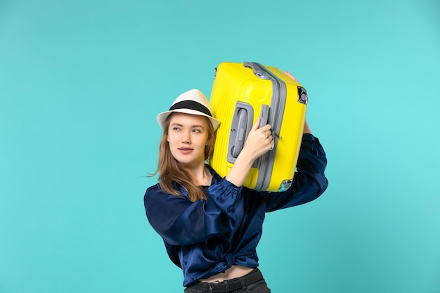 Vista frontal de la mujer joven que va de vacaciones y que sostiene una bolsa grande en un escritorio azul claro viaje viaje por mar viaje de vacaciones