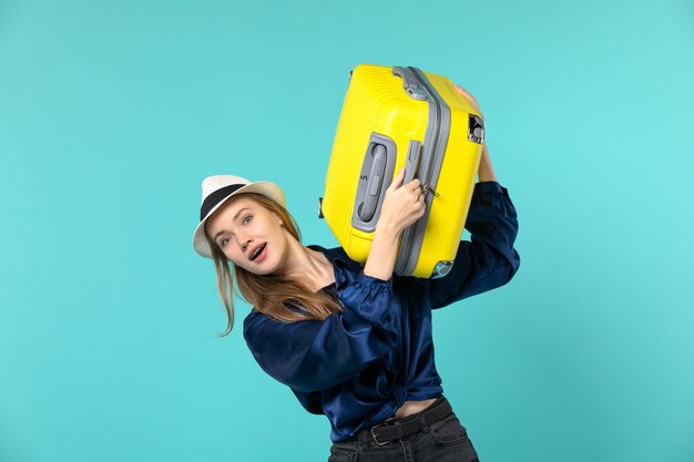 Vista frontal de la mujer joven que va de vacaciones y que sostiene una bolsa grande sobre fondo azul claro viaje viaje por mar viaje de vacaciones