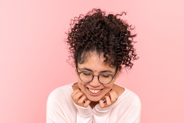 Vista frontal de la mujer joven riendo en rosa