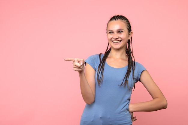 Vista frontal de la mujer joven riendo en rosa