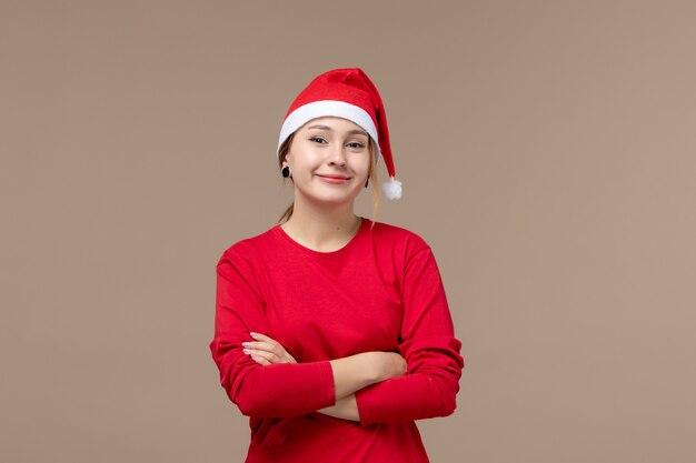 Vista frontal de la mujer joven con rostro sonriente en marrón