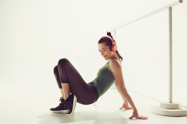 Vista frontal de una mujer joven sentada con auriculares