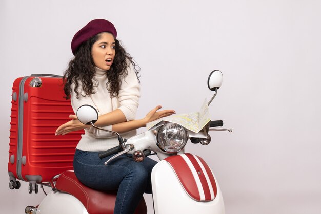 Vista frontal mujer joven sentada en bicicleta sobre fondo blanco vehículo de vacaciones motocicleta mujer ciudad carretera color