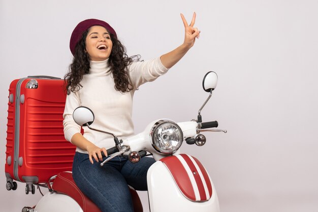 Vista frontal mujer joven sentada en bicicleta sobre fondo blanco velocidad del vehículo color motocicleta carretera mujer ciudad