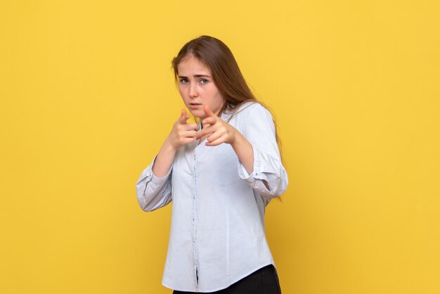 Vista frontal de la mujer joven sobre fondo amarillo modelo de belleza color mujer emoción