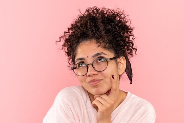 Vista frontal de la mujer joven soñando en rosa