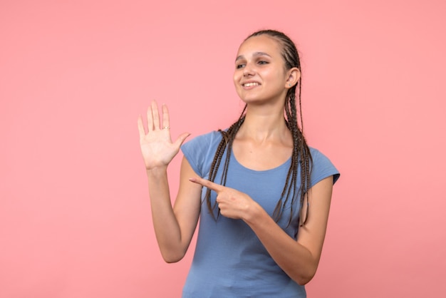 Vista frontal de la mujer joven sonriendo en rosa